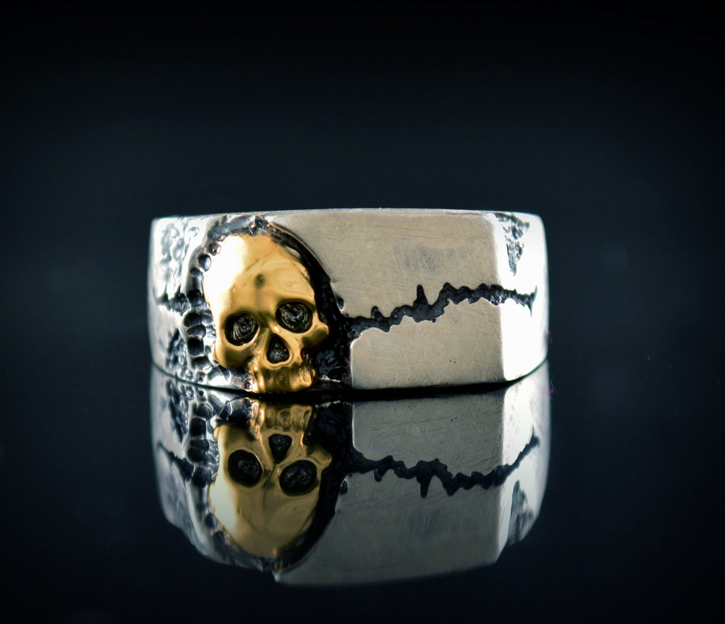 Anillo sello con textura de roca agrietada y una calavera