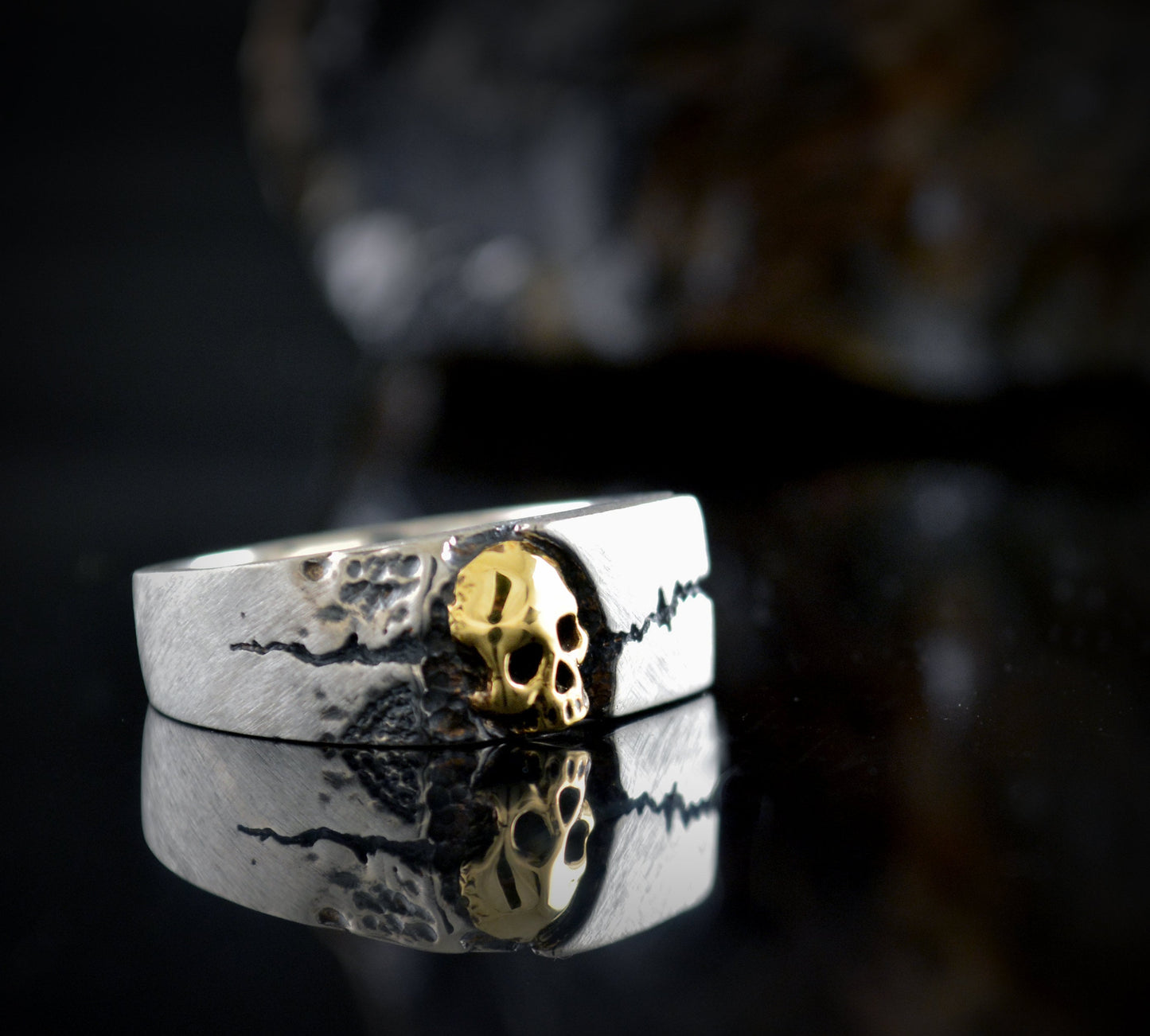 Anillo sello con textura de roca agrietada y una calavera
