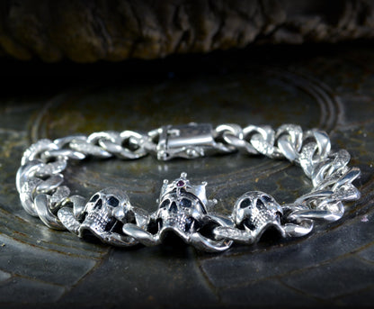 Massives Silberarmband mit drei Totenköpfen, kubanischen Kettengliedern und abschließbarem Kastenverschluss, Memento mori